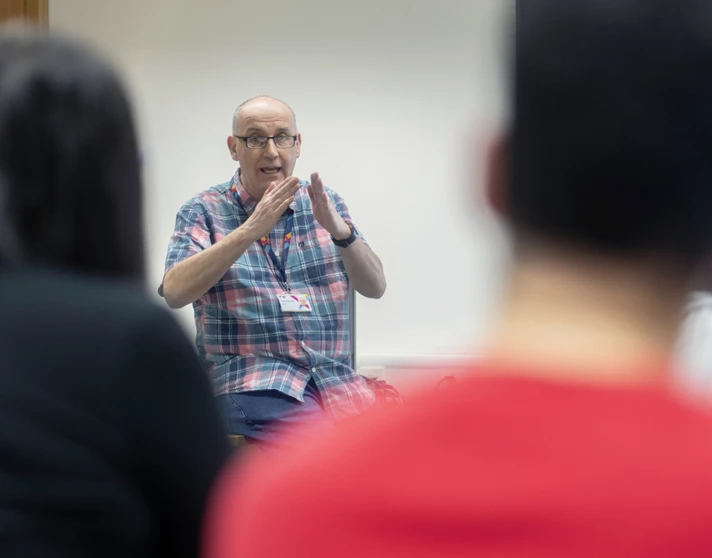 Lecturer uses hand gestures while explaining a topic to students in a humanities lesson. Lecturer uses hand gestures while explaining a topic to students in a humanities lesson.